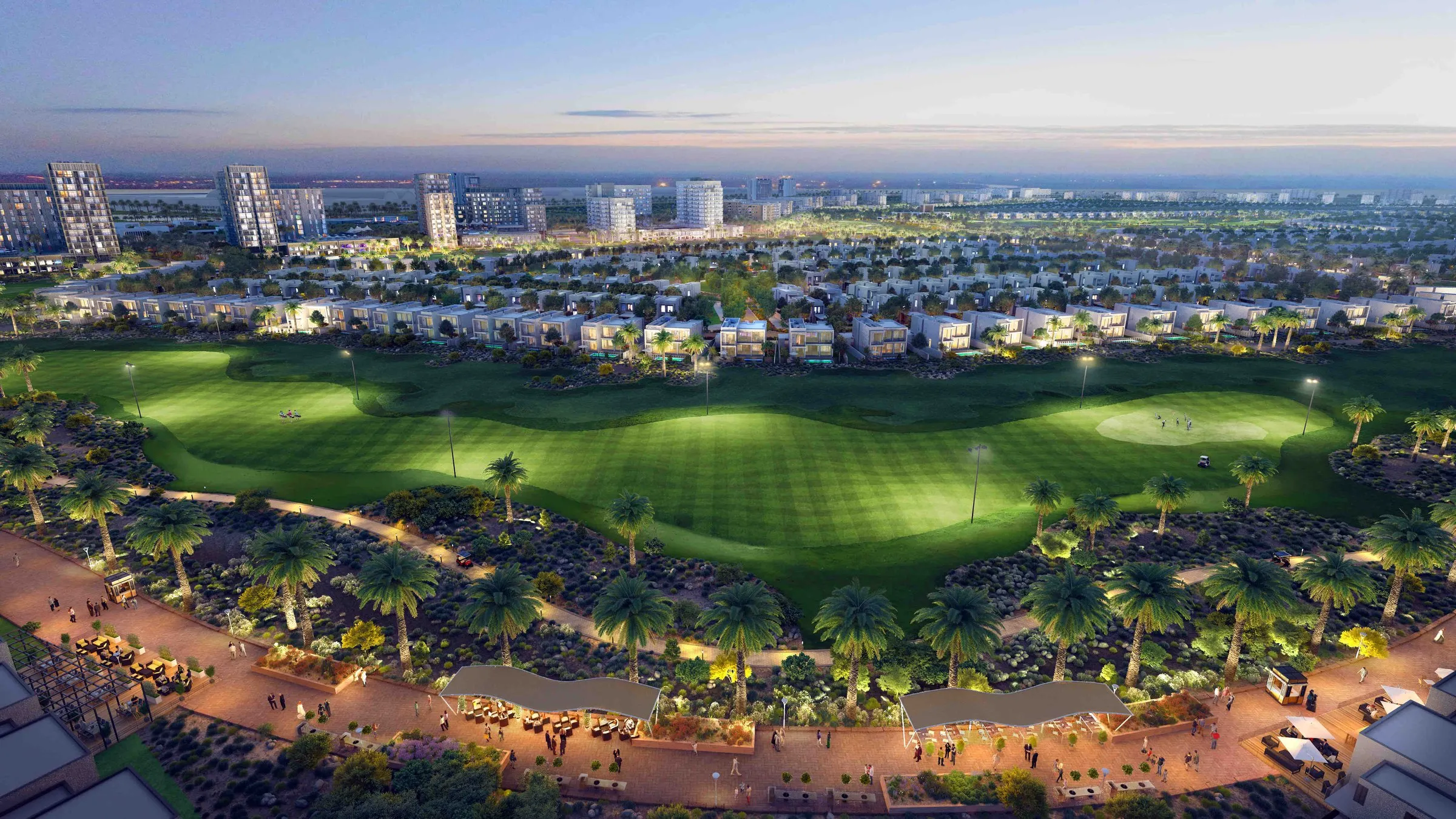 The Emaar South golf course and community lit up at dusk, seen from above